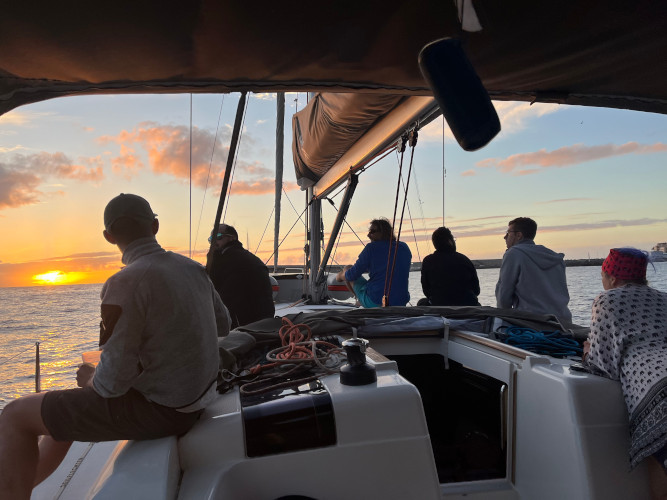 Crew relaxing together in the cockpit at sunset