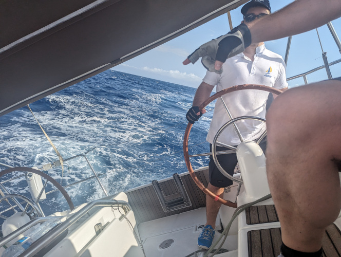 Two crew members coordinating a sail maneuver